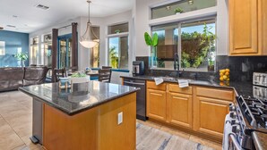 Una cocina moderna con armarios de madera, una isla central y un amplio ventanal que proporciona luz natural.