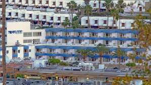A multi-story hotel with numerous rooms, some with balconies, and a few with views of the surrounding area. - Lufesa Apartments (Mogan)