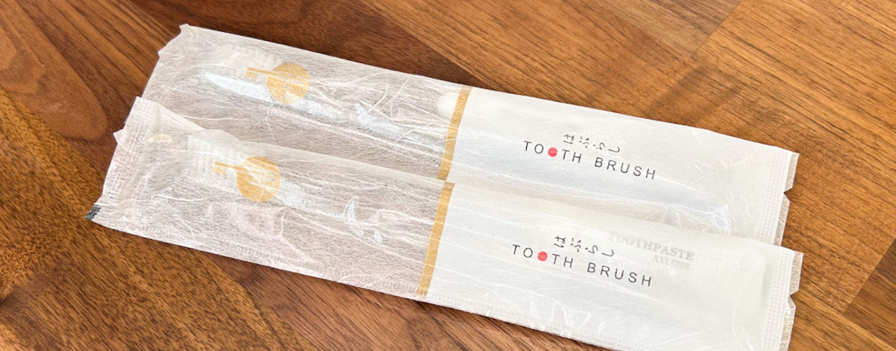Deux tubes de dentifrice étiquetés « BROSSE À DENTS » sont posés sur une surface en bois.
