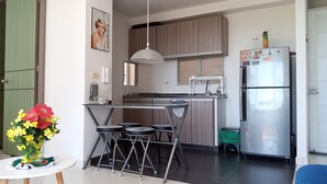 Une cuisine moderne avec un coin repas, des appareils en acier inoxydable et un luminaire suspendu.