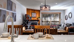 A modern kitchen with a marble countertop, a built-in stove, and wooden cabinetry.