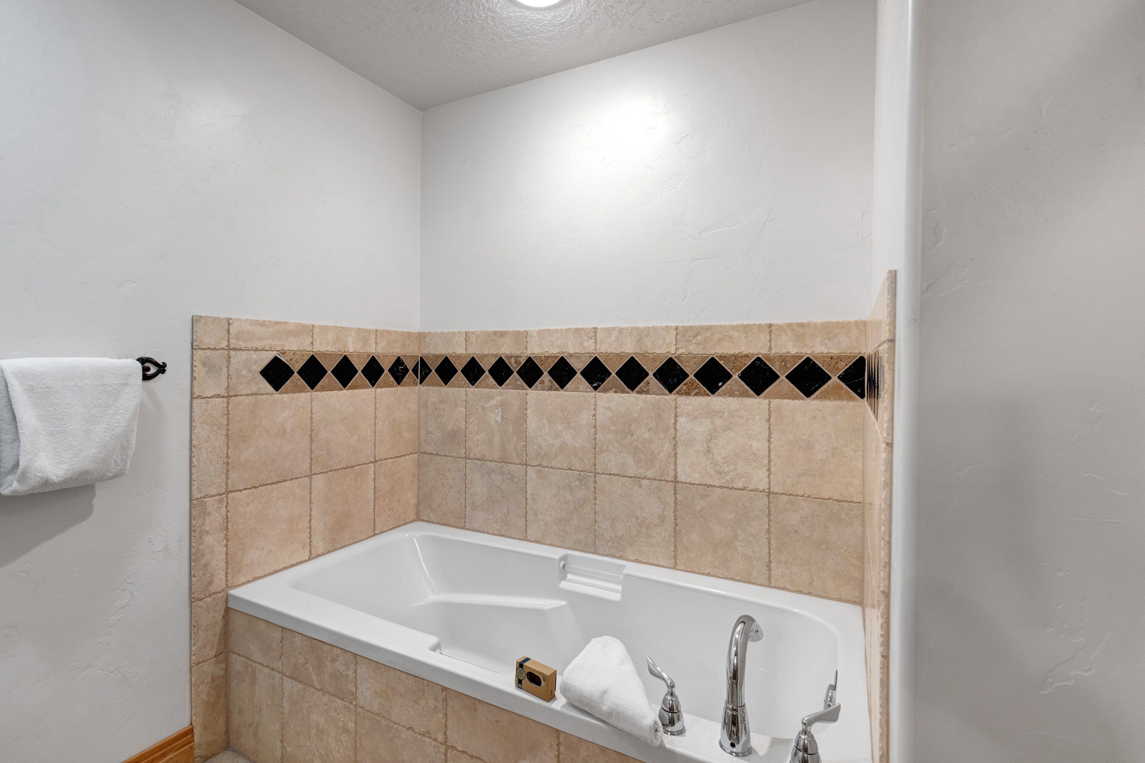 A bathroom with a bathtub, a towel rack, and a sink.