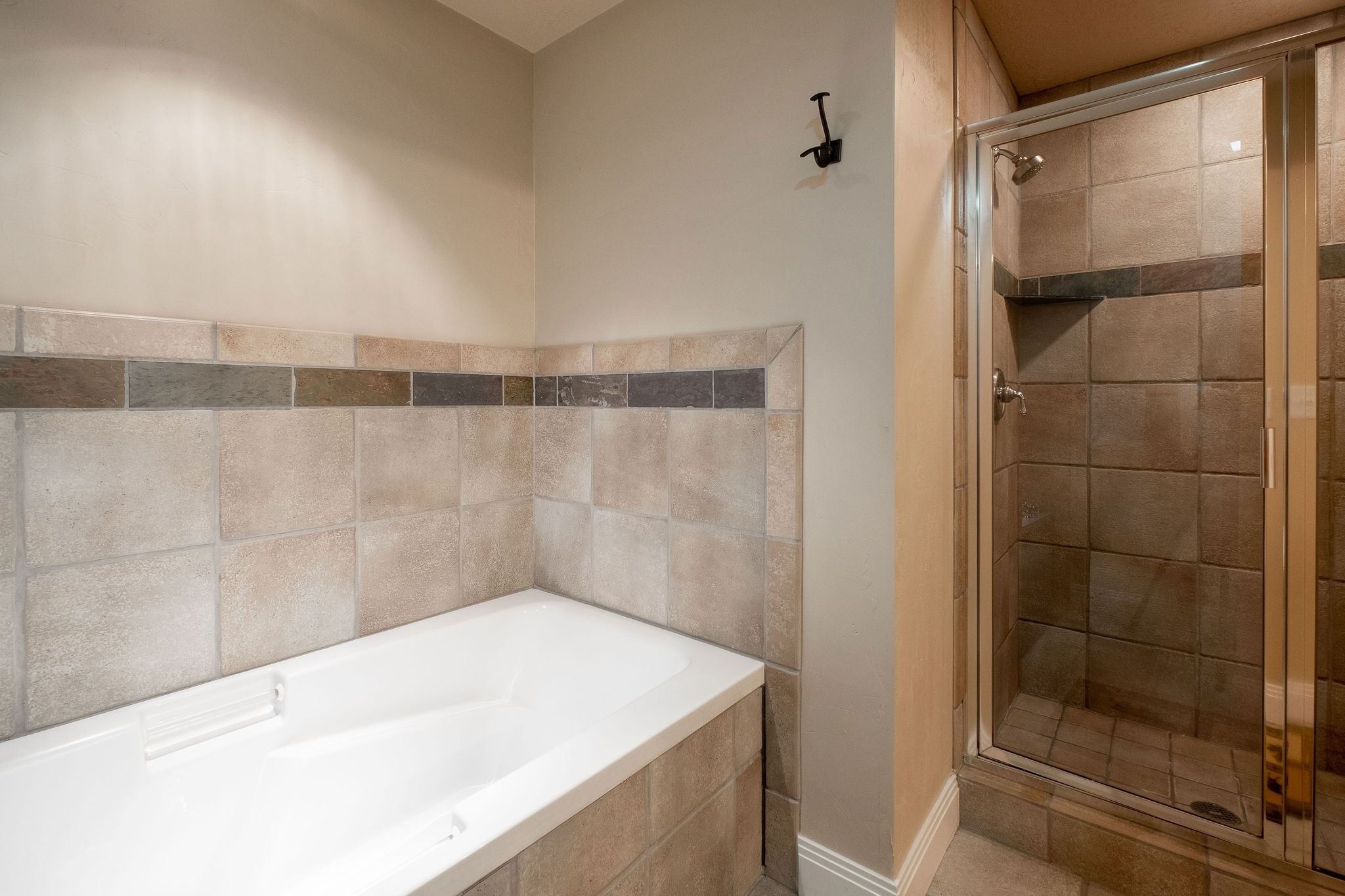 Un baño con bañera, cabina de ducha y salpicadero de azulejos.