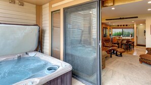 A hot tub in a covered outdoor area with a sliding glass door leading to a dining area. - Racquet Club 60 2 Bedroom Condo by RedAwning (Park City)