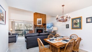 A modern living room with a fireplace, dining table, and seating area.