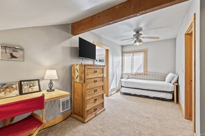 A bedroom with a desk, a dresser, a bed, a TV, and a ceiling fan. - Snow Flower 072 1 Bedroom Condo by RedAwning (Park City)
