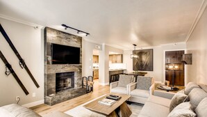 A modern living room with a fireplace, a sofa set, and a television.