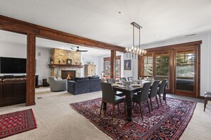 A spacious living room with a fireplace, a dining area with a large rug, and a cozy seating area. - Town Pointe B304 4 Bedroom Condo by RedAwning (Park City)
