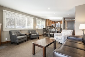 Relax in a spacious living area with a sofa, armchairs, and dining table.