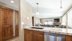 A kitchen with wooden cabinets, a stainless steel dishwasher, and a granite countertop.