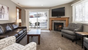 A living room with a fireplace, a television, and a couch.