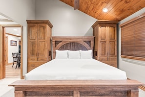 A bedroom with a large bed, wooden headboard, and built-in wardrobes. - Snow Flower 071 3 Bedroom Condo by RedAwning (Park City)