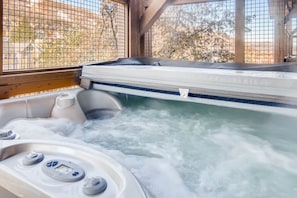 A hot tub with a control panel and a view through a window.
