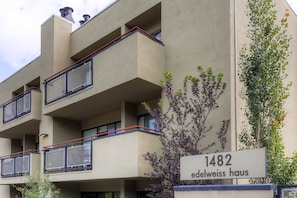 Um edifício de vários andares com varandas e uma placa indicando '1482 Edelweiss Haus'.