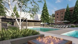 Ett modernt hotell med poolområde, solstolar och en eldstad.