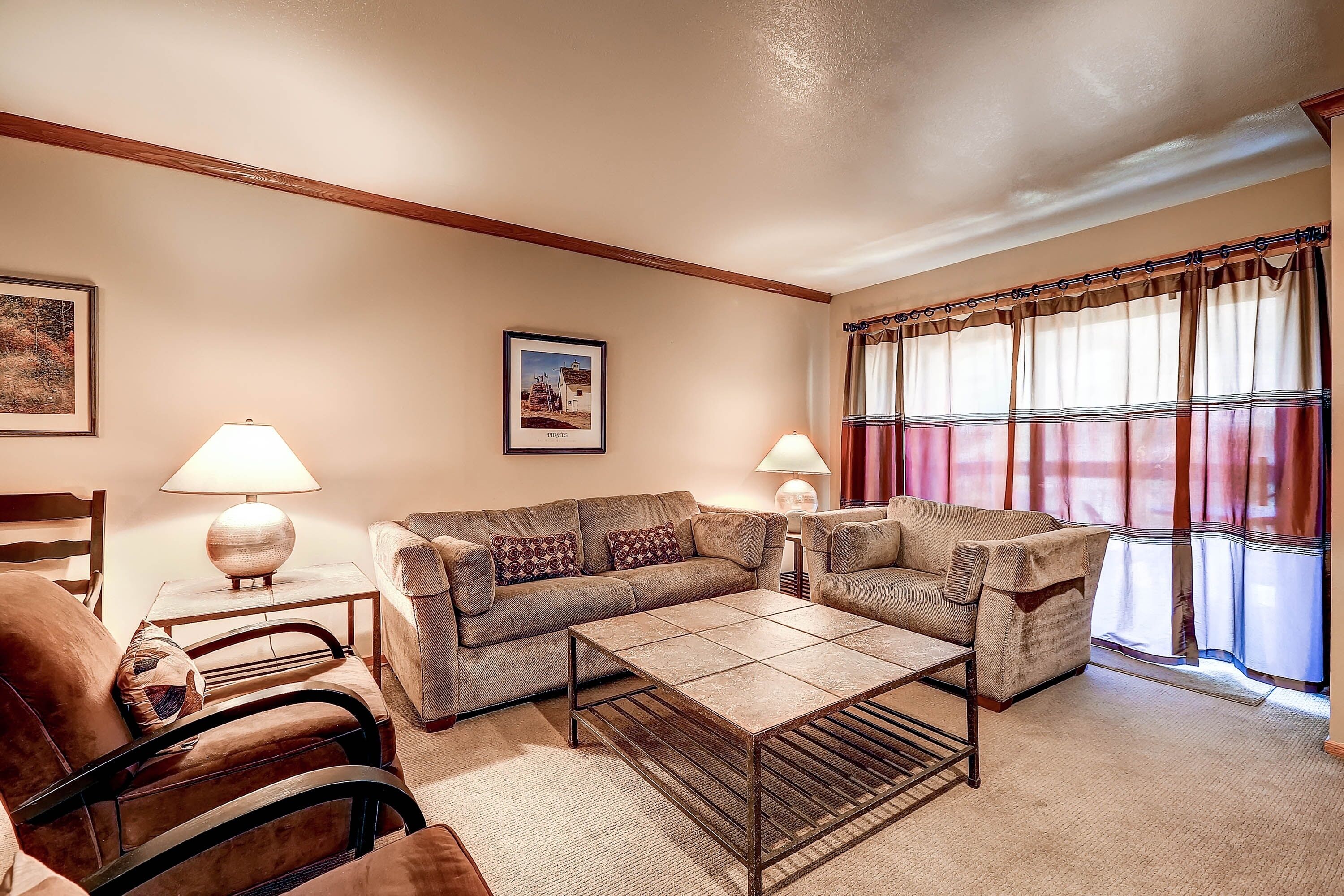A living room with a sofa set, a coffee table, and two lamps.