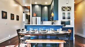 A modern kitchen with dark blue cabinets, a central island, and pendant lighting. - Woodside Haus 3 Bedroom Home by RedAwning (Park City)