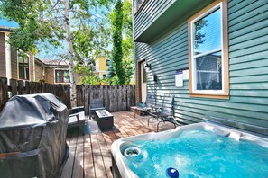 A backyard with a hot tub, a covered grill, and outdoor furniture. - Woodside Haus 3 Bedroom Home by RedAwning (Park City)