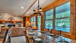 A dining area with a wooden table set for six, surrounded by wicker chairs. - Comstock 203 2 Bedroom Condo by RedAwning (Park City)