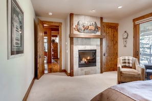 Une pièce chaleureuse avec une cheminée, des portes en bois et une vue sur l’extérieur.