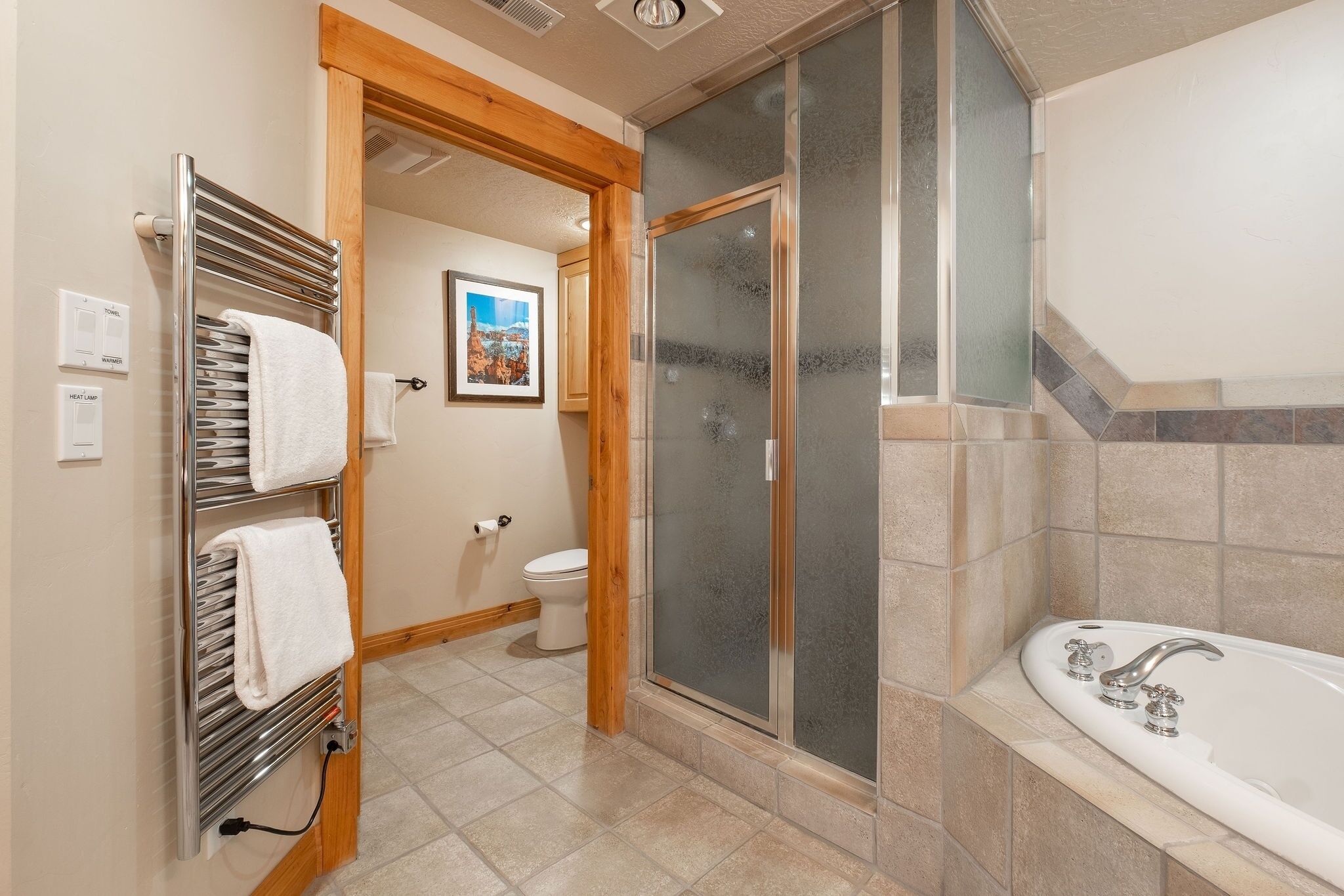 Une salle de bain avec une douche à parois de verre, une baignoire et un porte-serviettes avec des serviettes pliées.