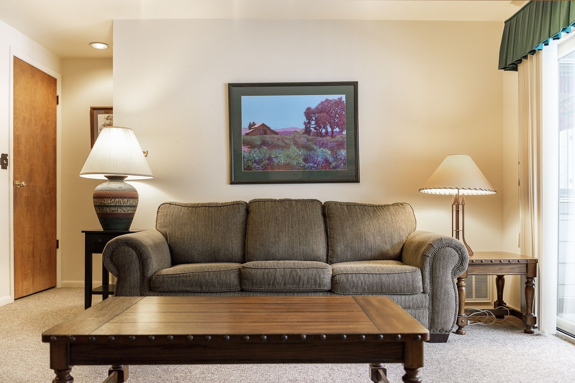A living room with a sofa, a coffee table, and two lamps.