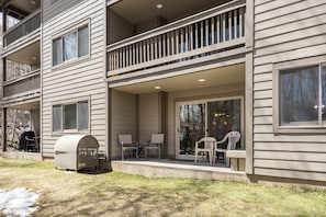 Enjoy outdoor dining or relaxation on the covered porch with a seating area and large window offering a view.