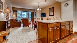 A spacious kitchen with wooden cabinets, a large island, and a dining area with a couch and chairs.