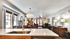 A modern kitchen with a dishwasher, wooden cabinets, and a large island.