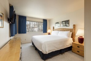 Relax in a spacious room with a large bed, two bedside tables, and a dresser.