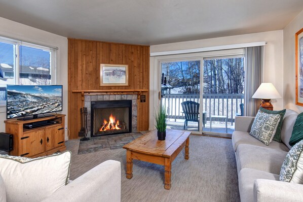 Cozy living room with a fireplace, flat-screen TV, and comfortable sofa.