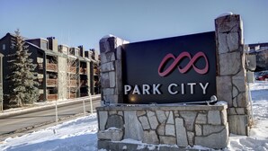 Ein Schild für Park City mit modernem Design und Steinsockel.