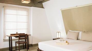 A bedroom with a bed, a desk, and a chair.