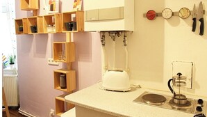 Une cuisine équipée d’un plan de travail, d’une machine à café et d’étagères en bois.