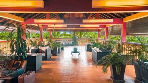 A covered outdoor area with seating, potted plants, and a view of greenery. - Le Siddharta D'Angkor (Siem Reap)