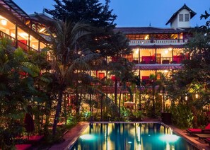 A multi-story hotel with a swimming pool surrounded by lush greenery. - Le Siddharta D'Angkor (Siem Reap)