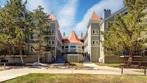 A multi-story residential building with a central courtyard, featuring a symmetrical design with red-tiled roofs and a central gazebo.