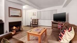 A living room with a fireplace, a television, a sofa, and a coffee table.