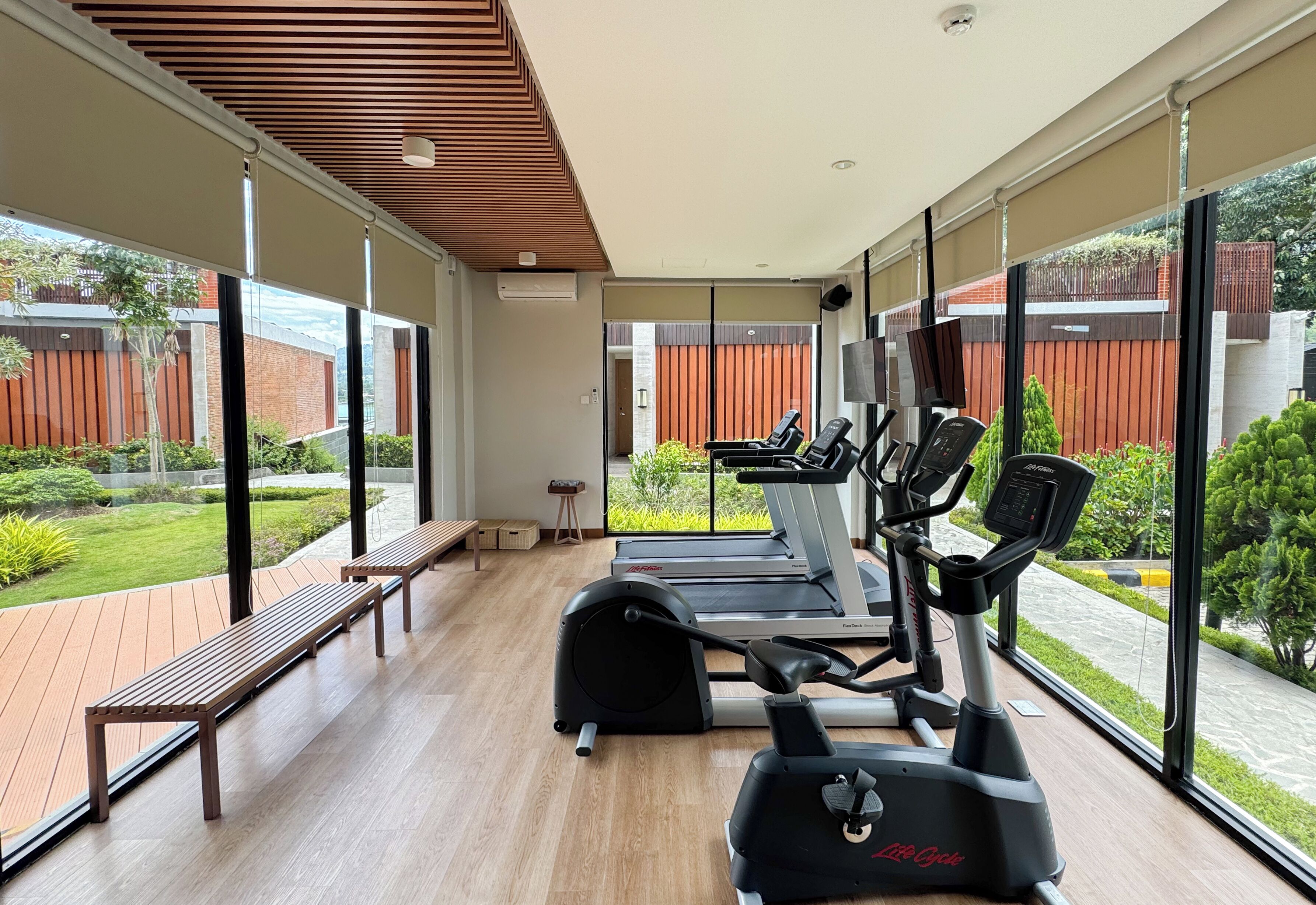 A modern gym with exercise equipment and a wooden deck.