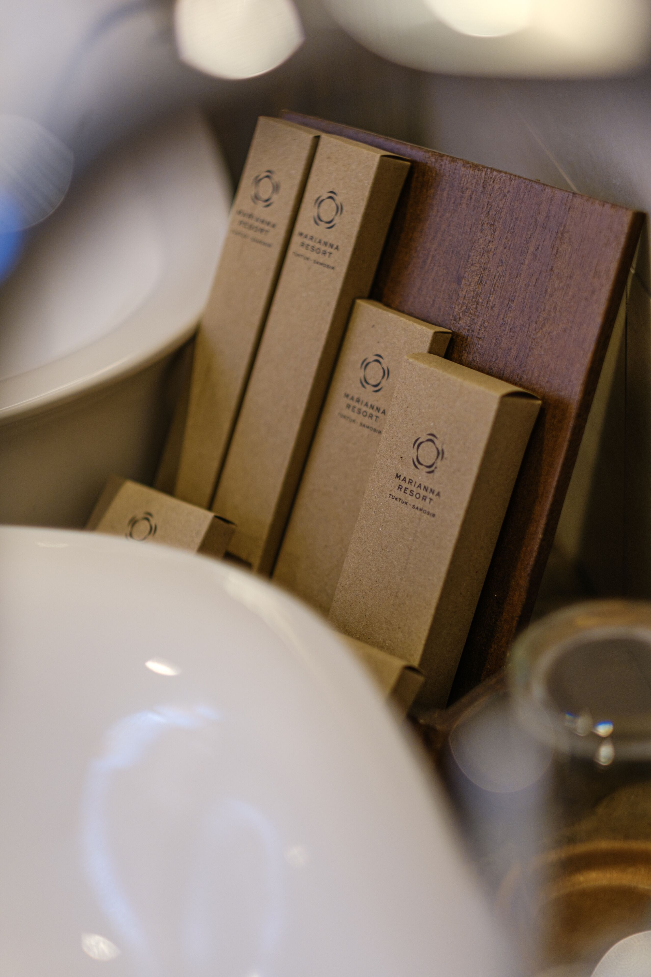 A set of brown paper bags with the Marianna Resort logo, placed in a wooden holder.