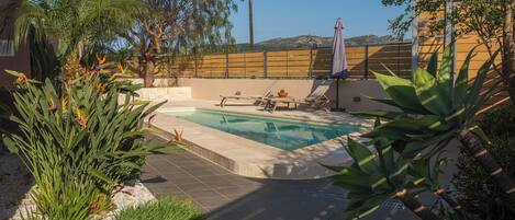 Een seizoensgebonden buitenzwembad, parasols voor strand/zwembad
