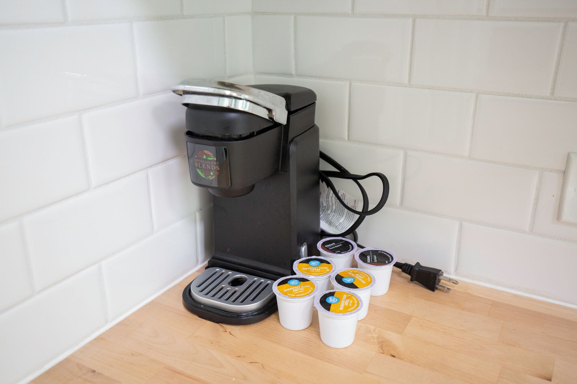 Een koffiezetapparaat met verschillende koffiecups op een houten oppervlak.