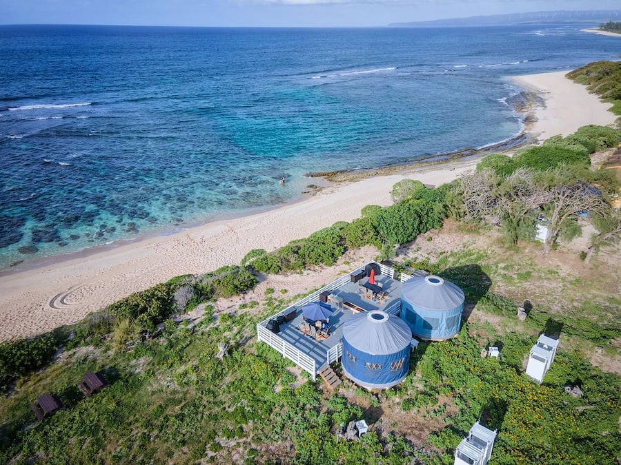 A coastal property with yurts, a beach, and a view of the sea.