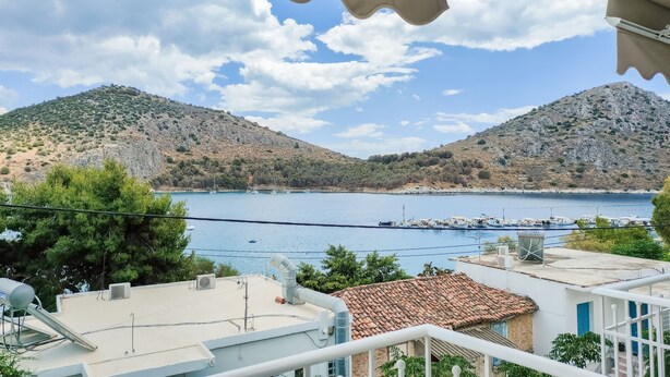 A coastal view with a clear sky, a calm sea, and a hilly landscape. - Akrotopi Apartments (Nafplio)
