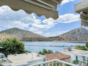 A coastal view with a clear sky, a calm sea, and a hilly landscape. - Akrotopi Apartments (Nafplio)