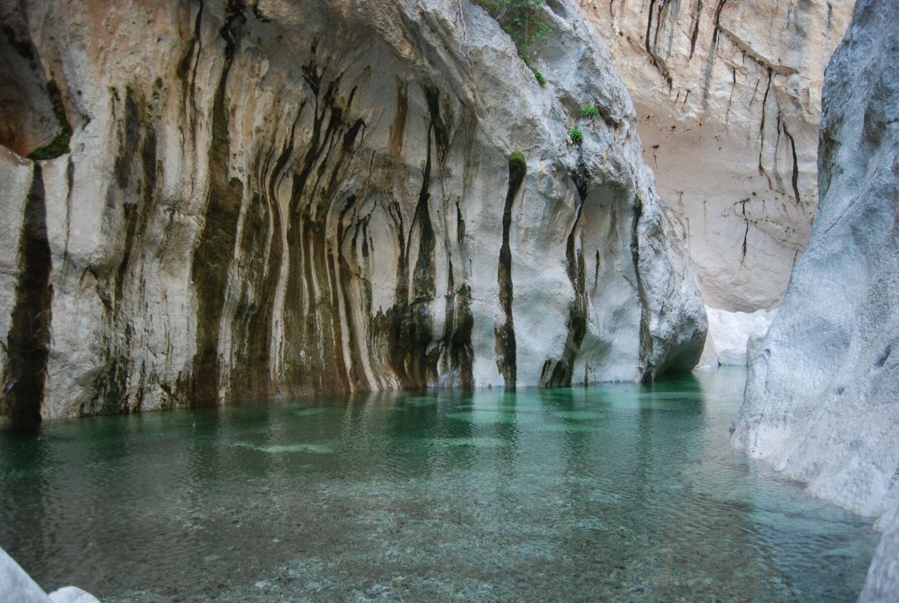 Una cueva natural con agua cristalina y formaciones rocosas.