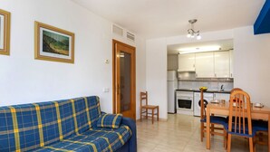 Una sala de estar con sofá y un comedor con mesa y sillas.