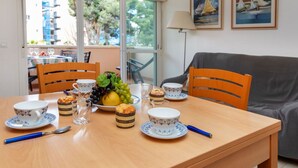 Ein Esstisch mit Obstschale, Tellern, Tassen und einer Lampe.
