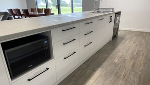 Een moderne keuken met een ingebouwde magnetron, een vaatwasser en een groot raam met uitzicht op de omgeving.