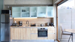 Uma cozinha moderna com forno embutido, cafeteira e micro-ondas.